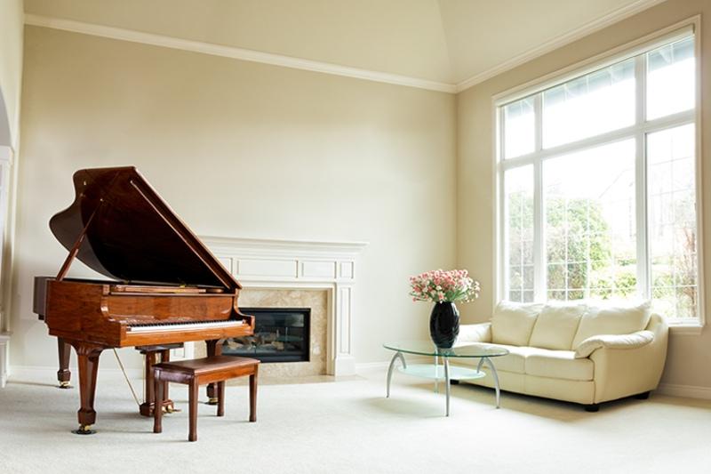 干净的客厅，浅米色的地毯和墙壁，壁炉和大钢琴显示出良好的室内空气质量.